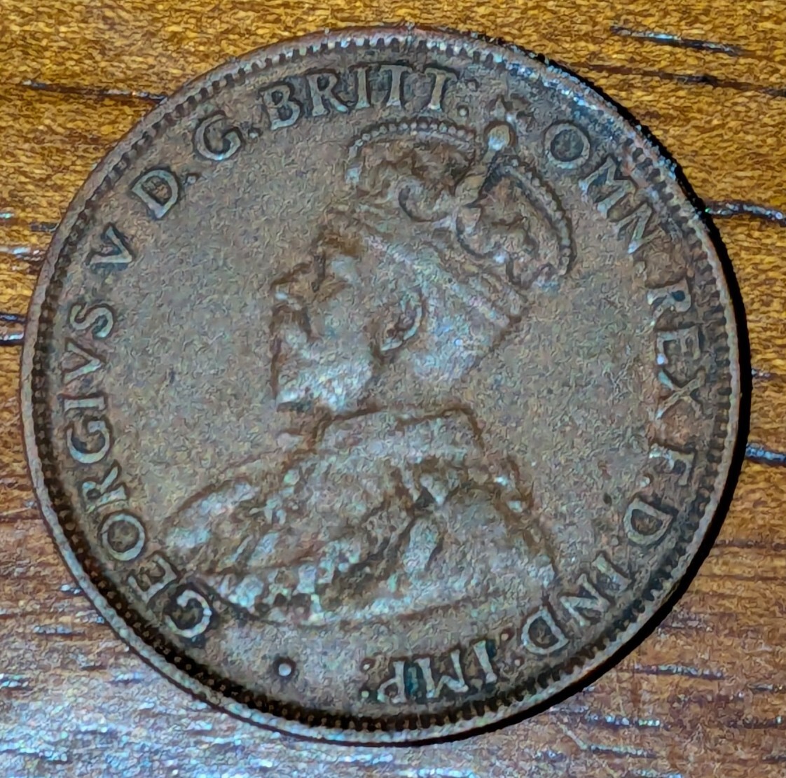 A rusted coin showing King George V's profile