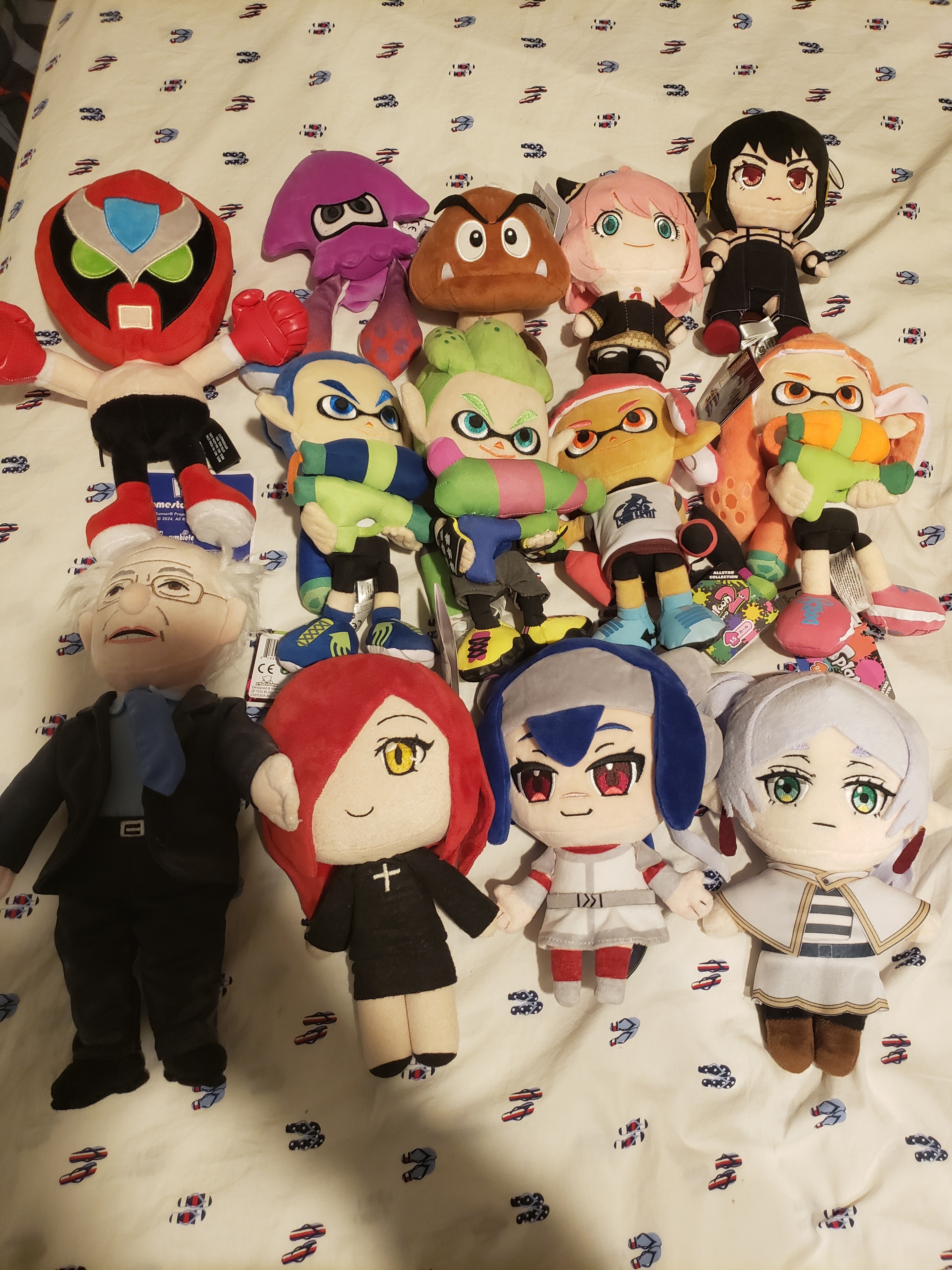 A bunch of plushies Strong Bad, Inkling Squid (Purple), Goomba, Anya Forger, Yor Forger Inkling Boy (Blue), Inkling Boy (Green), Inkling Girl (Pink), Inkling Girl (Orange) Bernie Sanders, Parasoul, Lea, Frieren