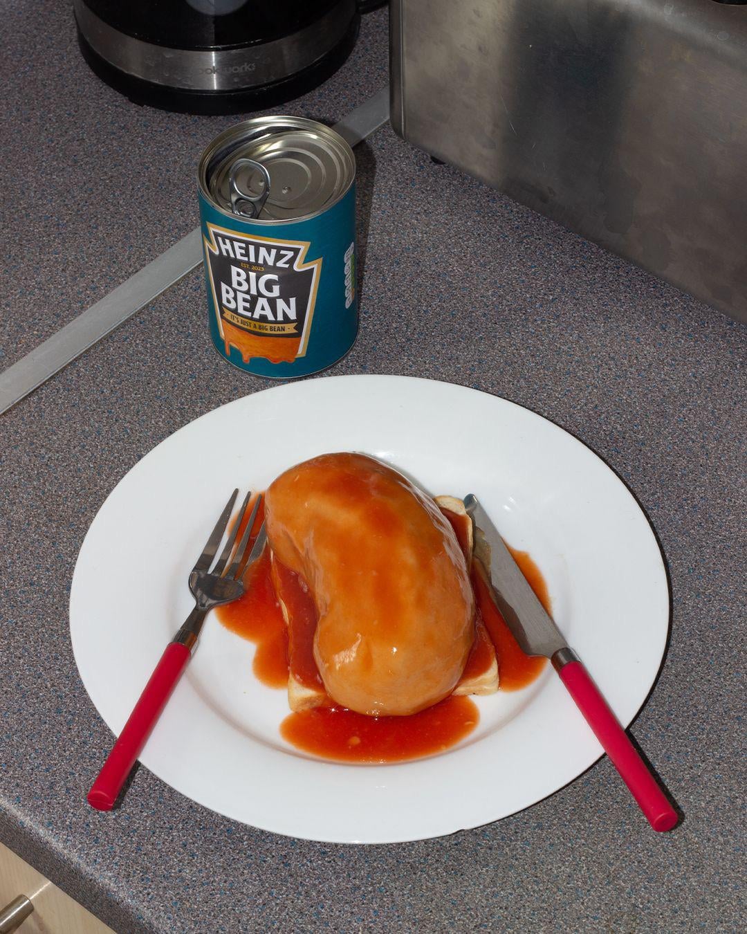 An image of a giant bean on a plate next to a can that says "Heinz: Big Bean - It's just a big bean"