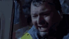 GIF of Dennis Nedry from Jurassic Park getting sprayed in the face with a dinosaurs venom. He screams and stumbles trying to get into his car