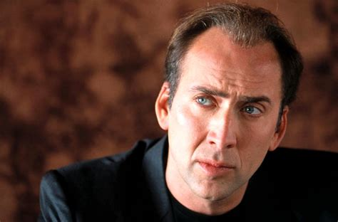 photo of nicolas cage, brown background,  black shirt, shows from base of neck up