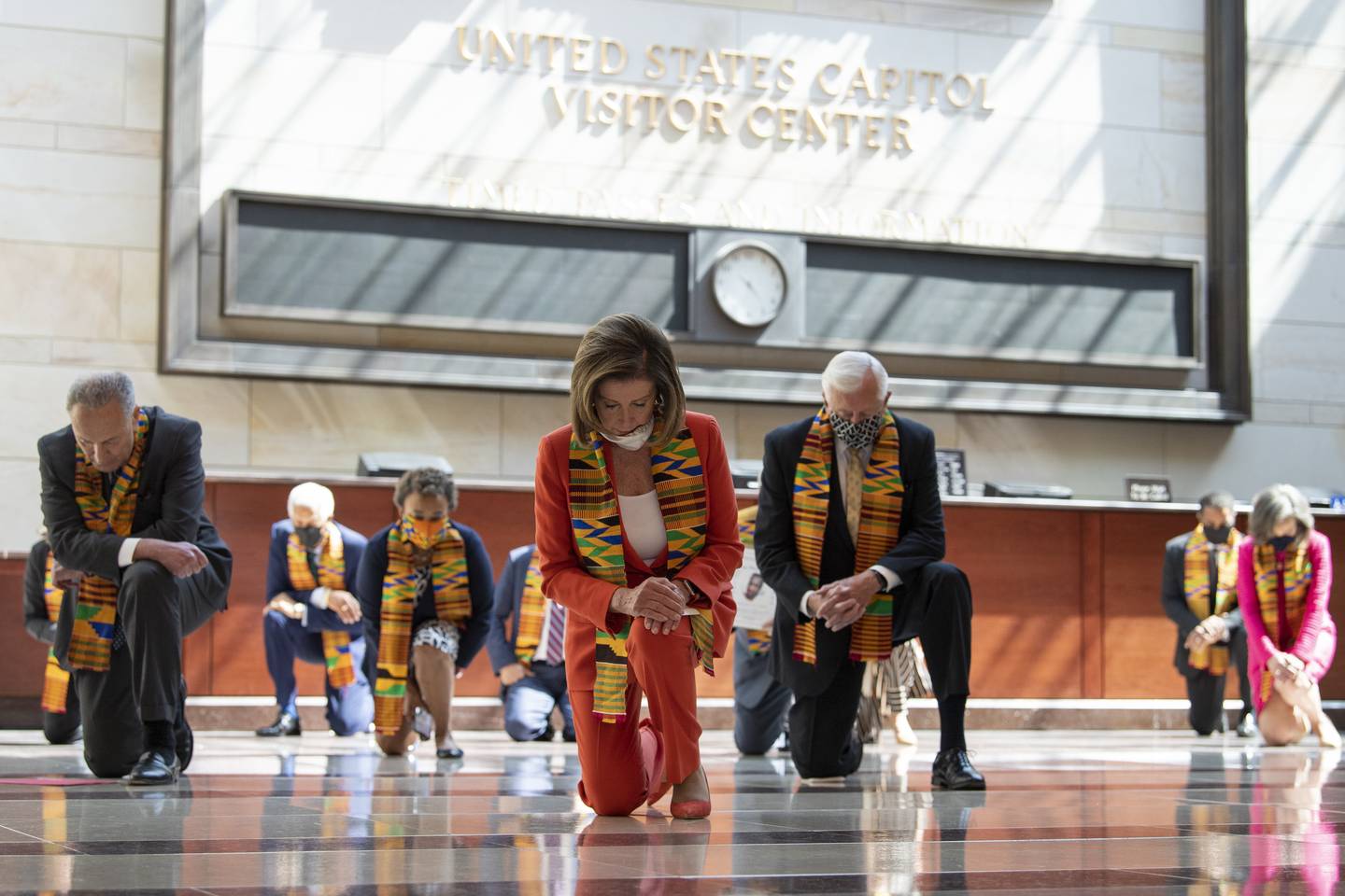Democrats kneeling wearing African garb in feigned solidarity with African Americans