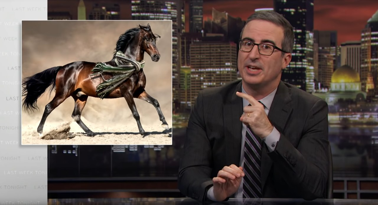 screenshot from Last Week Tonight with John Oliver gesturing towards an image of a stallion wearing a green scarf and glasses